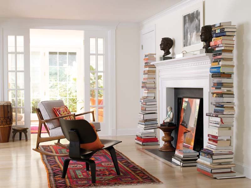 zona lectura con chimenea mecedora y estanterías verticales para libros