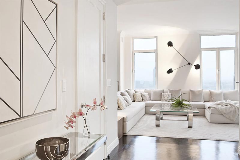 Salón blanco con cristaleras y vistas a Nueva York por Kelly Behun