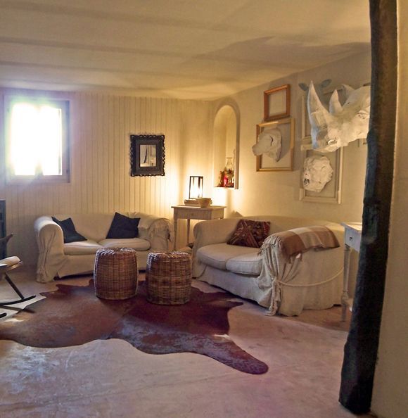 salón paredes forradas paneles blancos sofas blancos cabezas animales papel