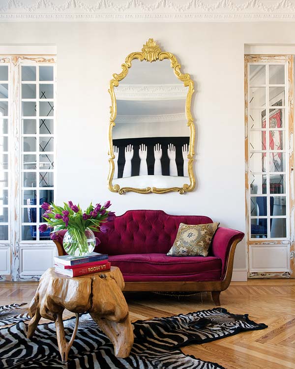 sofa-capitoné-berenjena-alfombra-cebra-espejo-dorado