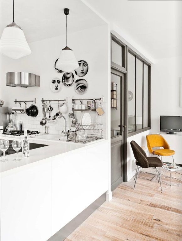 cocina integrada con salón blanco platos fornasetti