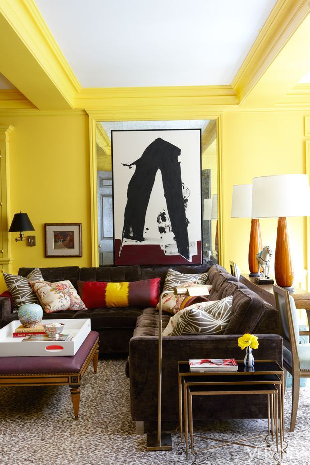 Salón pintado amarillo sofás terciopelo marrón