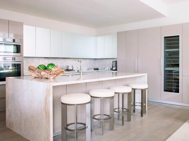 cocina-amplia-moderna-isla-central-de-marmol-con-taburetes-estilo-femenino