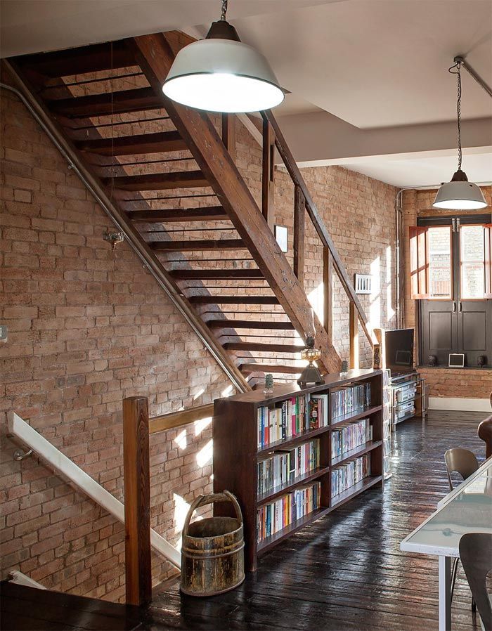 2-libreria-estanterias-madera-salon-paredes-ladrillo-antiguo-almacen-londres-sofa-cuero-viejo