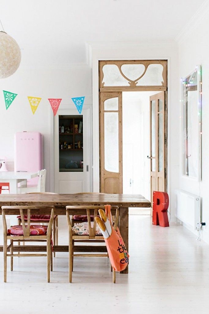 En el comedor: mesas de madera y sillas con respaldos envolventes ...