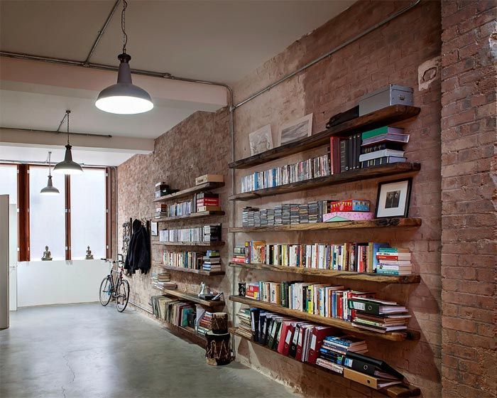 libreria-estanterias-madera-salon-paredes-ladrillo-antiguo-almacen-londres-sofa-cuero-viejo