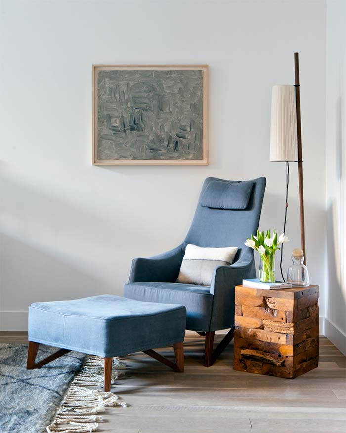 piso-decorado-con-muebles-de-madera-estilo-moderno-rincon-lectura-butaca-con-reposapies-azul-
