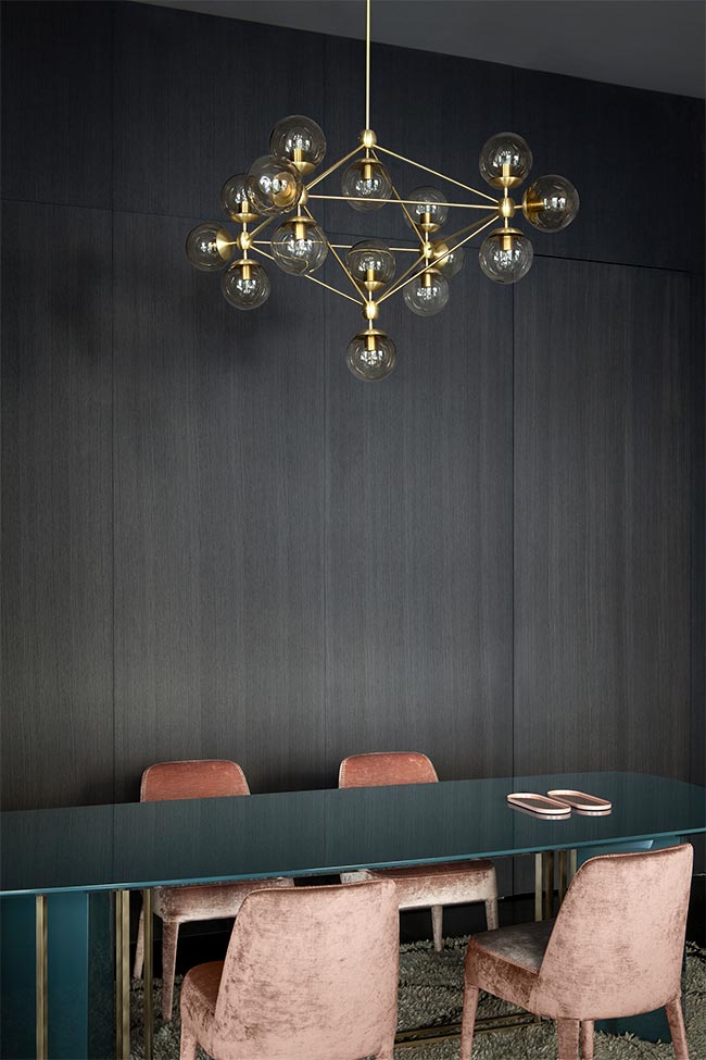comedor-pared-negra-lampara-techo-dorada-y-sillas-rosa