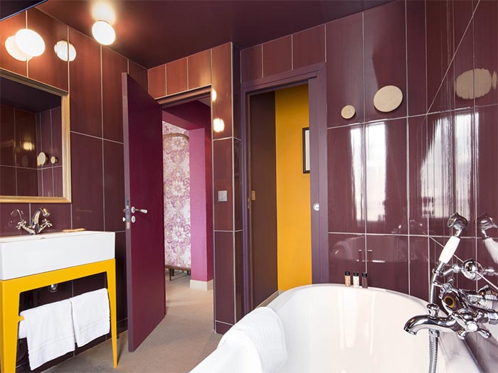 bano-azulejos-violeta-y-mueble-lavabo-amarillo
